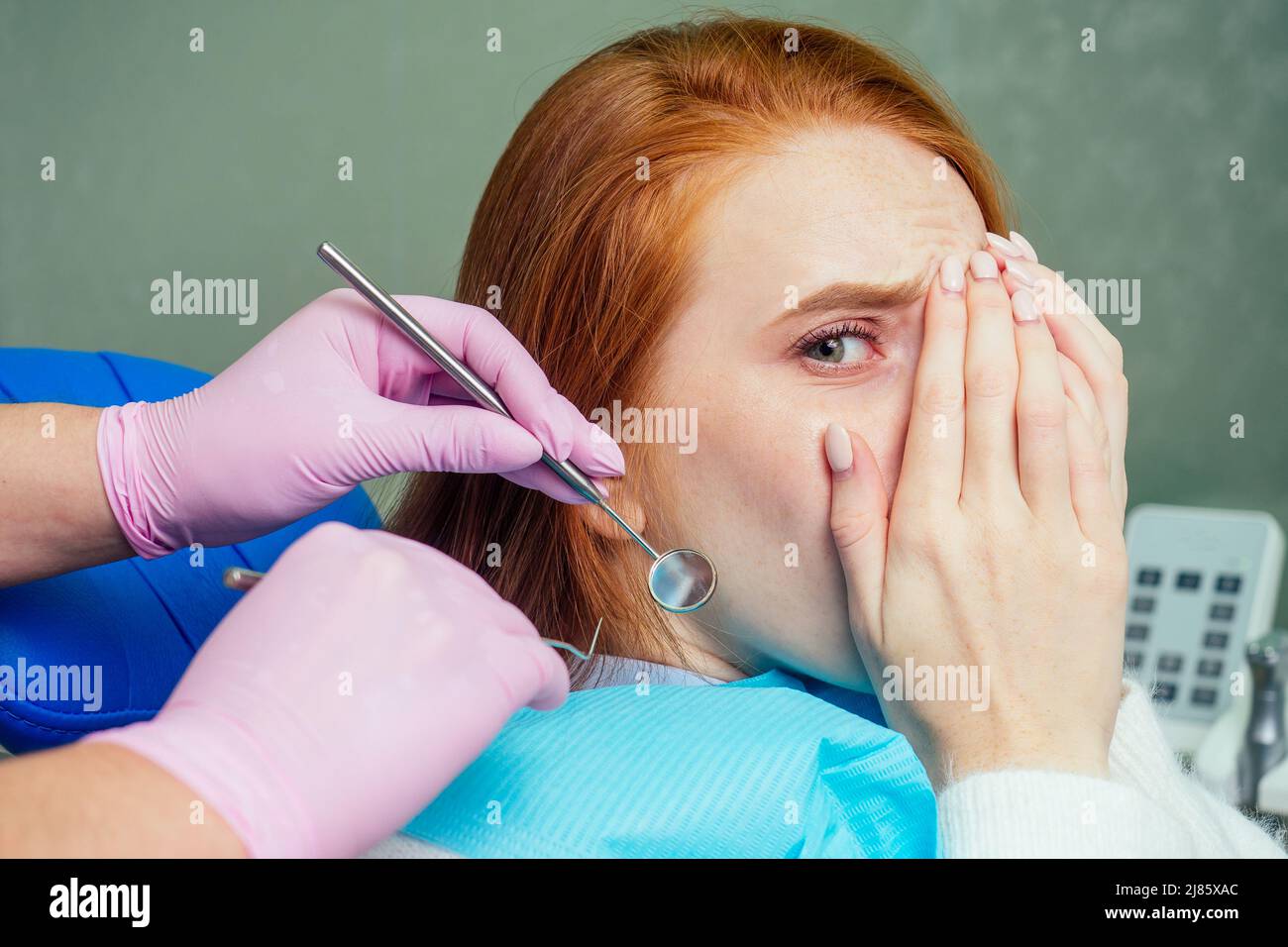 lo zenzero rosso ha sollecitato la paziente femminile paura al check-up esame dentale in clinica Foto Stock