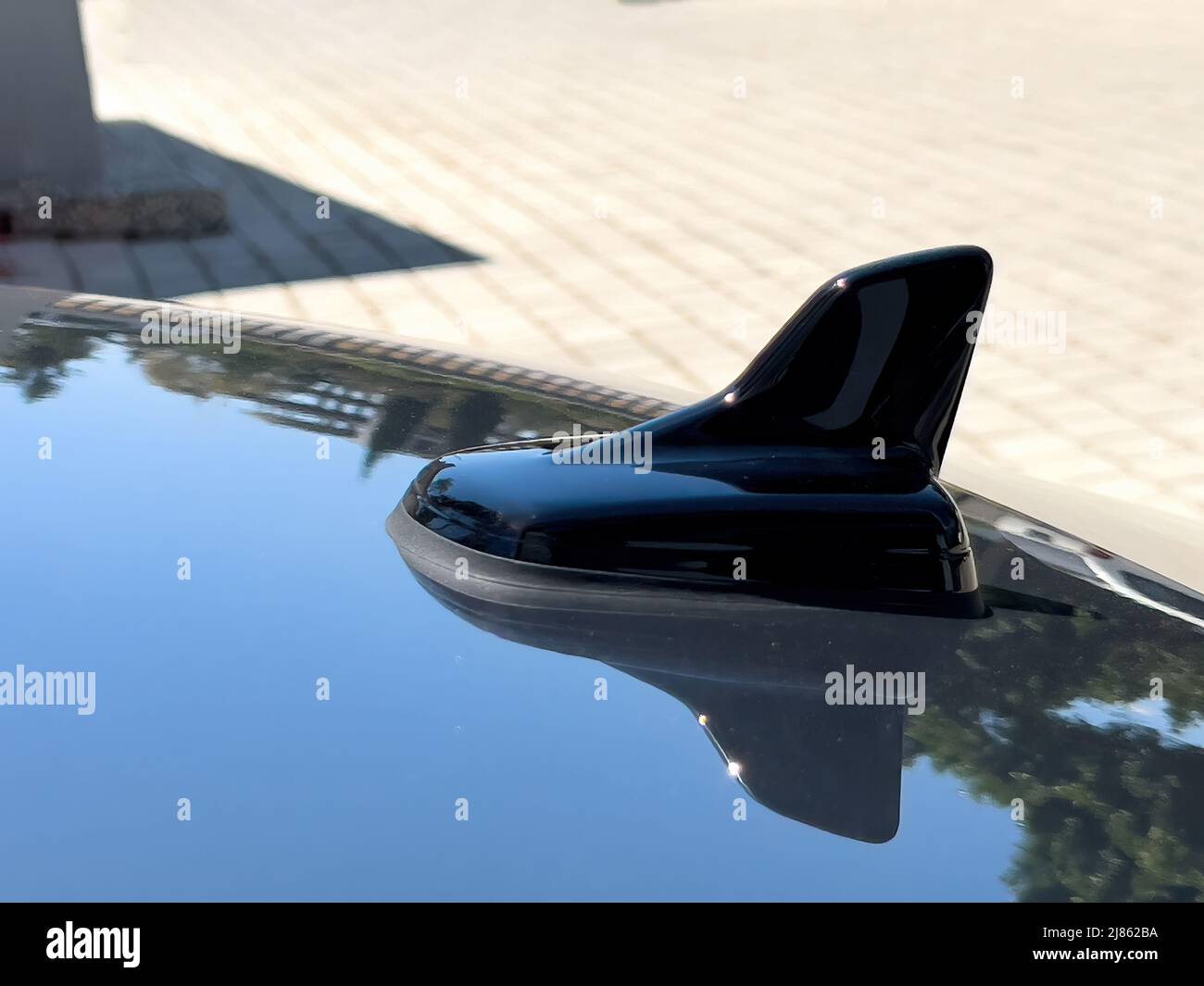 Antenna Shark su auto di lusso nera in giorno di sole Foto Stock