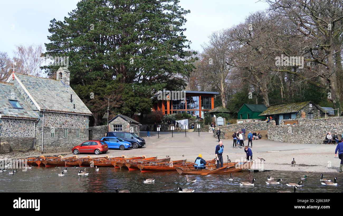 Noleggio barche a remi a riva con Keswick Theatre by the Lake sullo sfondo Foto Stock