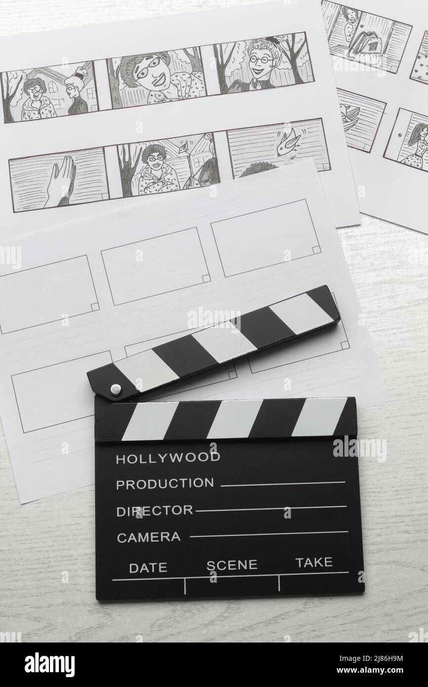 Schizzi disegnati storyboard di personaggi per un film o cartoon con un clapperboard sul desktop. Foto Stock