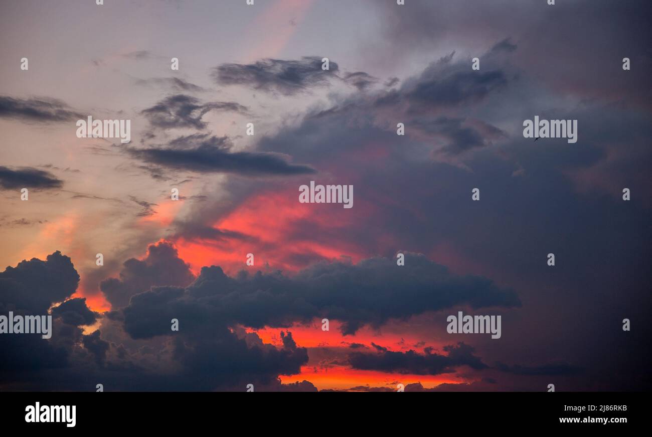 spettacolare cielo al tramonto con luce solare arancione e nuvole Foto Stock