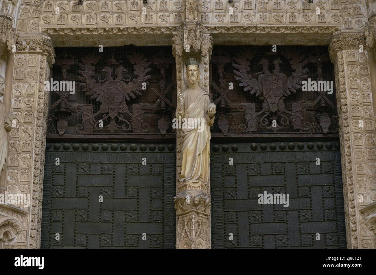 Spagna, Castiglia-la Mancha, Toledo. Cattedrale di Santa Maria. Eretto in stile gotico tra il 1227 e il 1493. Facciata principale. Porta del perdono. Costruito sotto la direzione dell'architetto Alvar Martínez (attivo tra il 1418 e il 1440). Particolare di Cristo Salvatore scolpito sul mullion e le porte in bronzo. Queste impronte sono datate 1337. Foto Stock