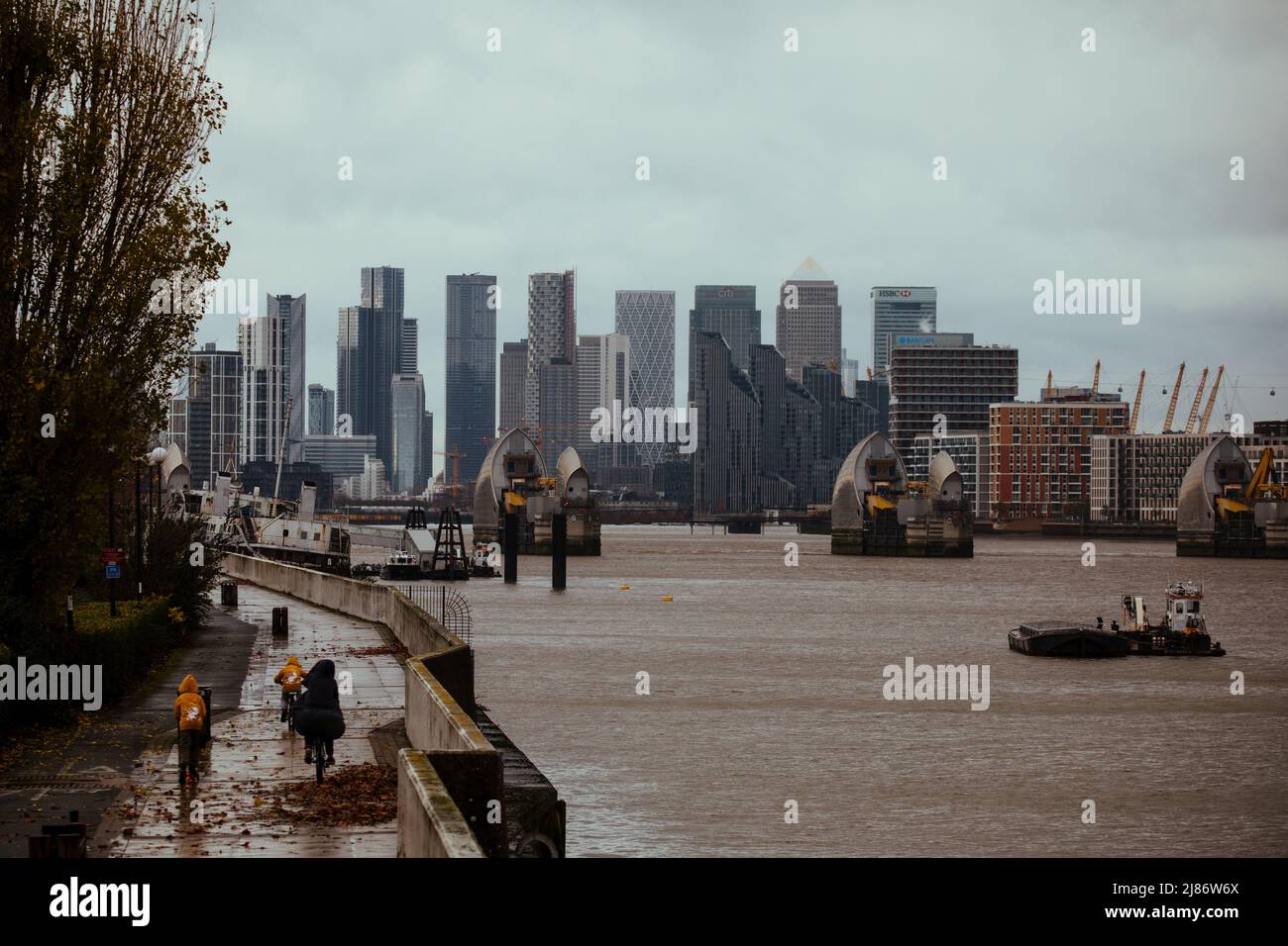 Il Tamigi Barrier con Canary Wharf sullo sfondo, Londra Foto Stock
