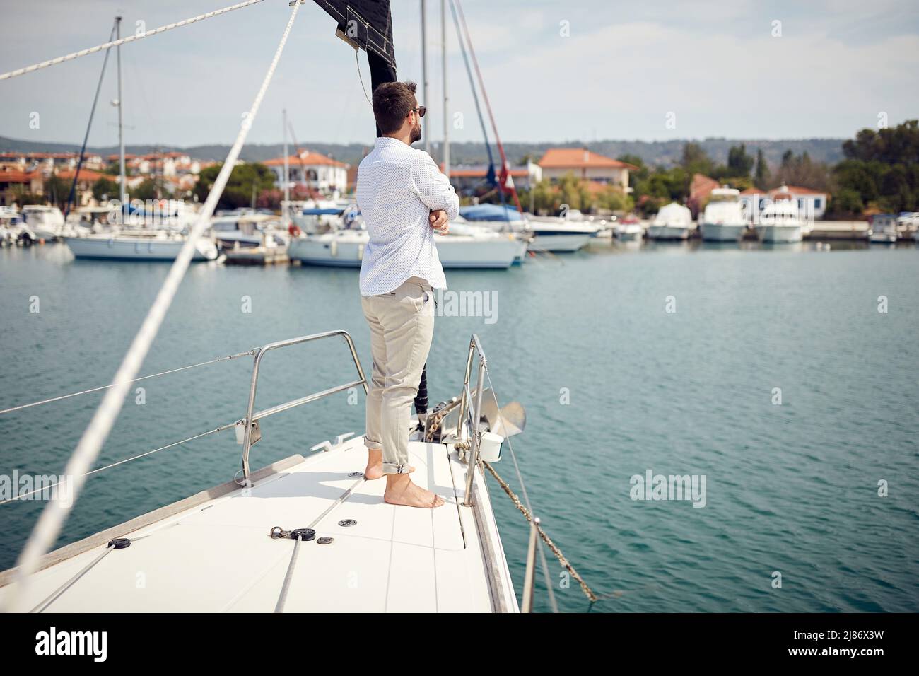 L'uomo attraente e informale che naviga da solo sullo yacht Foto Stock