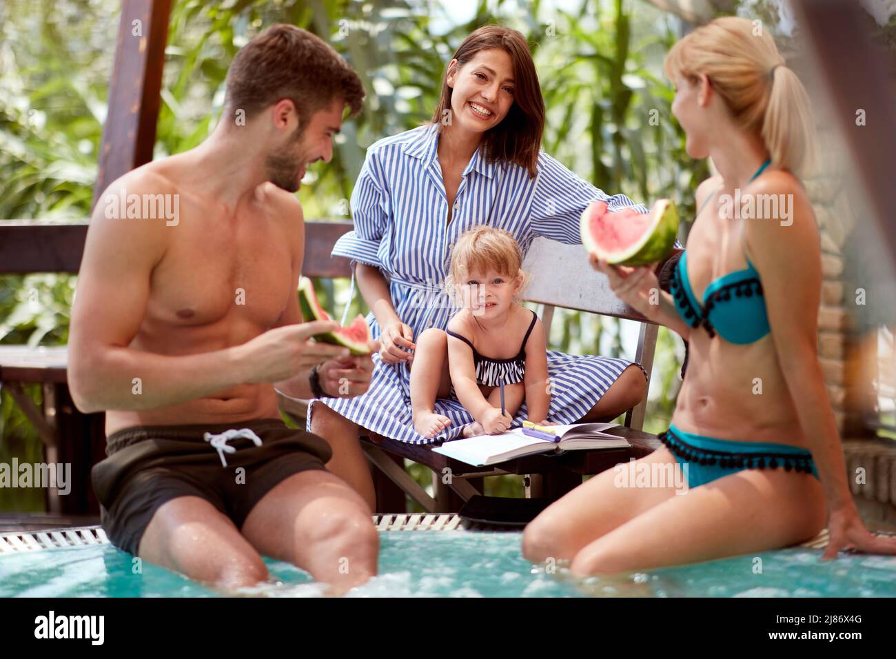 Famiglia con bambino citer in estate in piscina Foto Stock