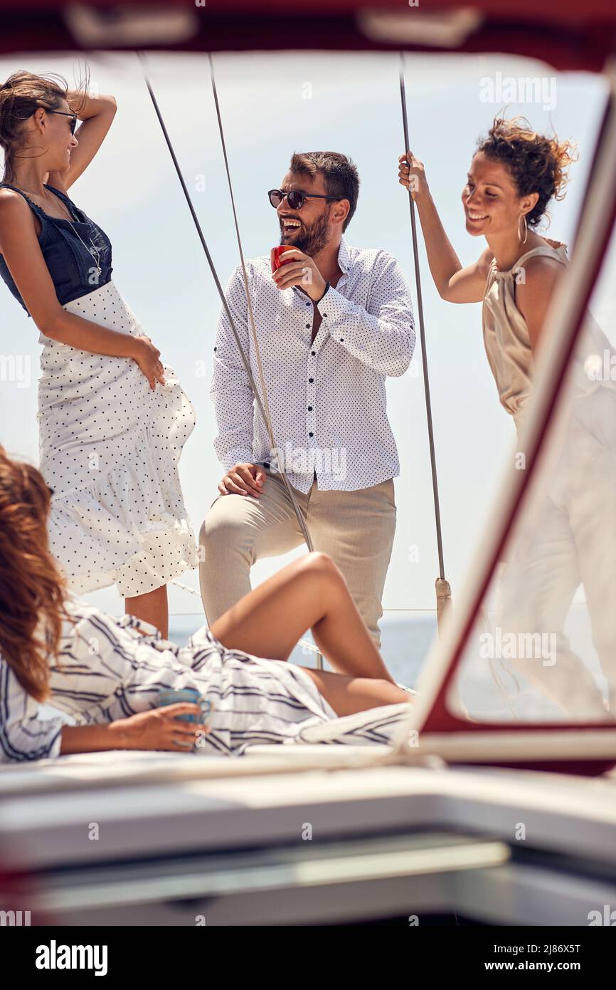 Gruppo di amici ricchi di classe che si divertono insieme sullo yacht; concetto di stile di vita di lusso Foto Stock