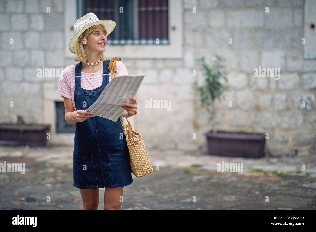 Donna felice in vacanza godendo in bella strada della città alla mappa Foto Stock