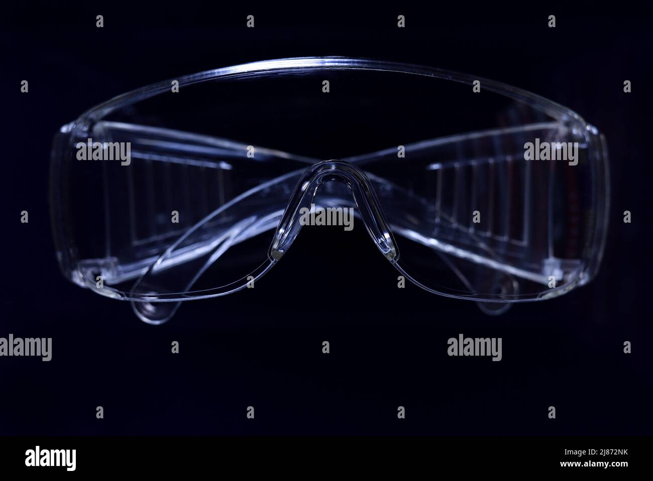 Occhiali protettivi su sfondo scuro, concetto di salute e sicurezza. Occhiali di sicurezza su sfondo nero. Dispositivi di protezione individuale. Occhiali di protezione. Foto Stock