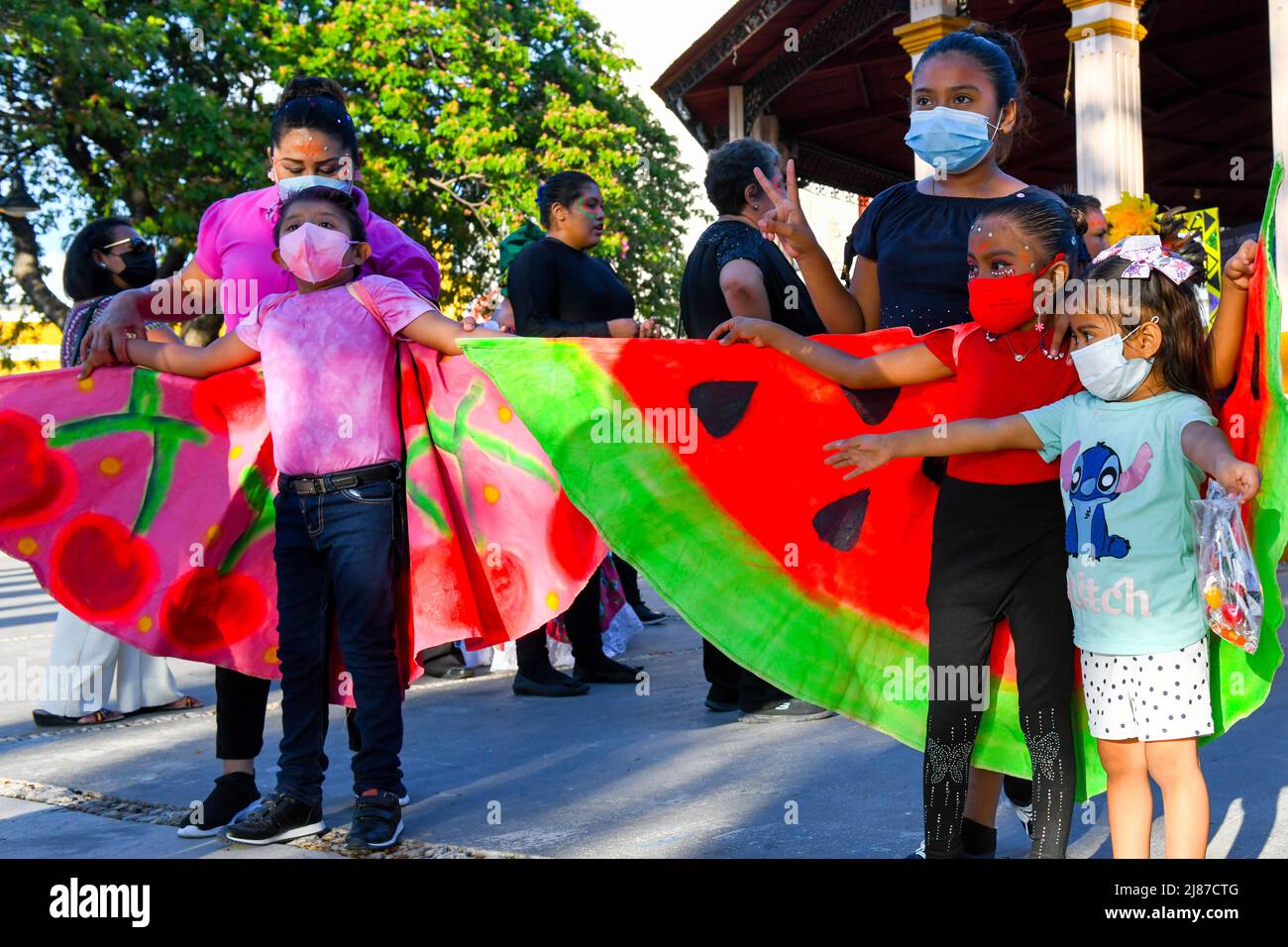 Bambini dopo uno spettacolo sulla piazza principale, Campeche, Messico / le autorità sanitarie pubbliche messicane hanno permesso agli eventi di riprendere chiedendo alla gente di continuare a indossare maschere per la protezione dal virus Covid-19 , aprile 2022 Foto Stock