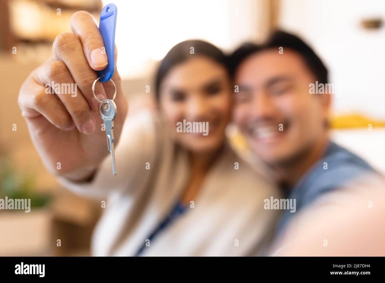 Felice giovane coppia asiatica con chiave casa in nuovo appartamento Foto Stock