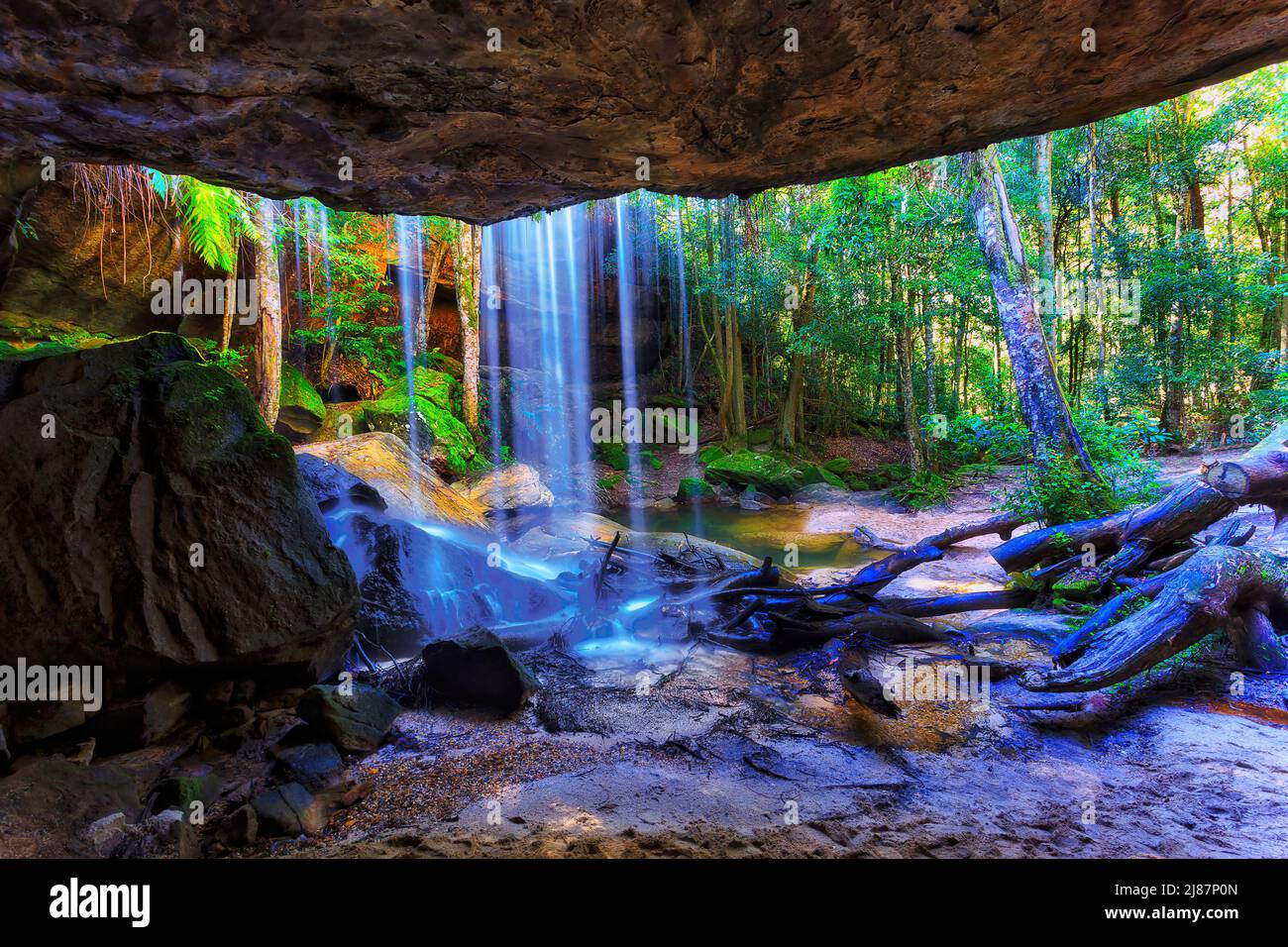 All'interno di una scenografica grotta di arenaria nel parco nazionale delle Blue Moutains in Australia dietro la cascata di Oakland. Foto Stock