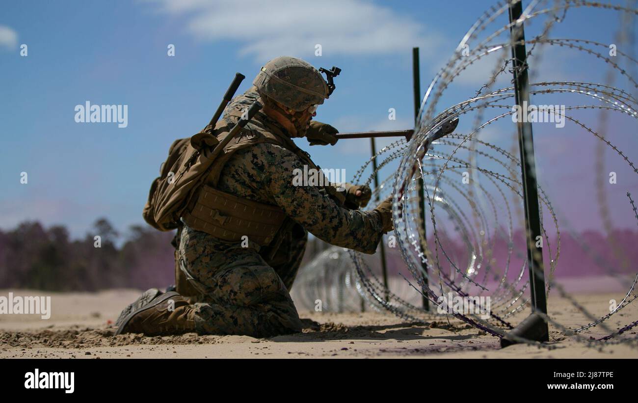 Una Marina degli Stati Uniti con 2D Combat Engineer Battaglione, 2D Marine Division, taglia attraverso il filo di concertina durante il corso dei leader di Sapper su Camp Lejeune, North Carolina, 11 maggio 2022. Il corso Sapper Leaders offre ai leader della squadra di ingegneri di combattimento le competenze tecniche e tattiche necessarie per fornire mobilità, controvobilità e superstite ai comandanti delle aziende di fanteria. (STATI UNITI Foto del corpo marino di Lance CPL. Ryan Ramsammy) Foto Stock