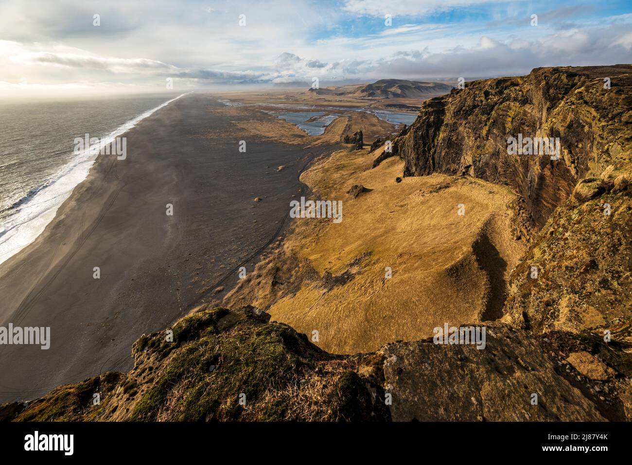 Vista panoramica della sabbia di lava nera della spiaggia di Dyrhólafjara, Islanda, vista dalla roccia degli uccelli di Dyrhólaey con le sue scogliere giganti, vicino a Vík í Mýrdal Foto Stock