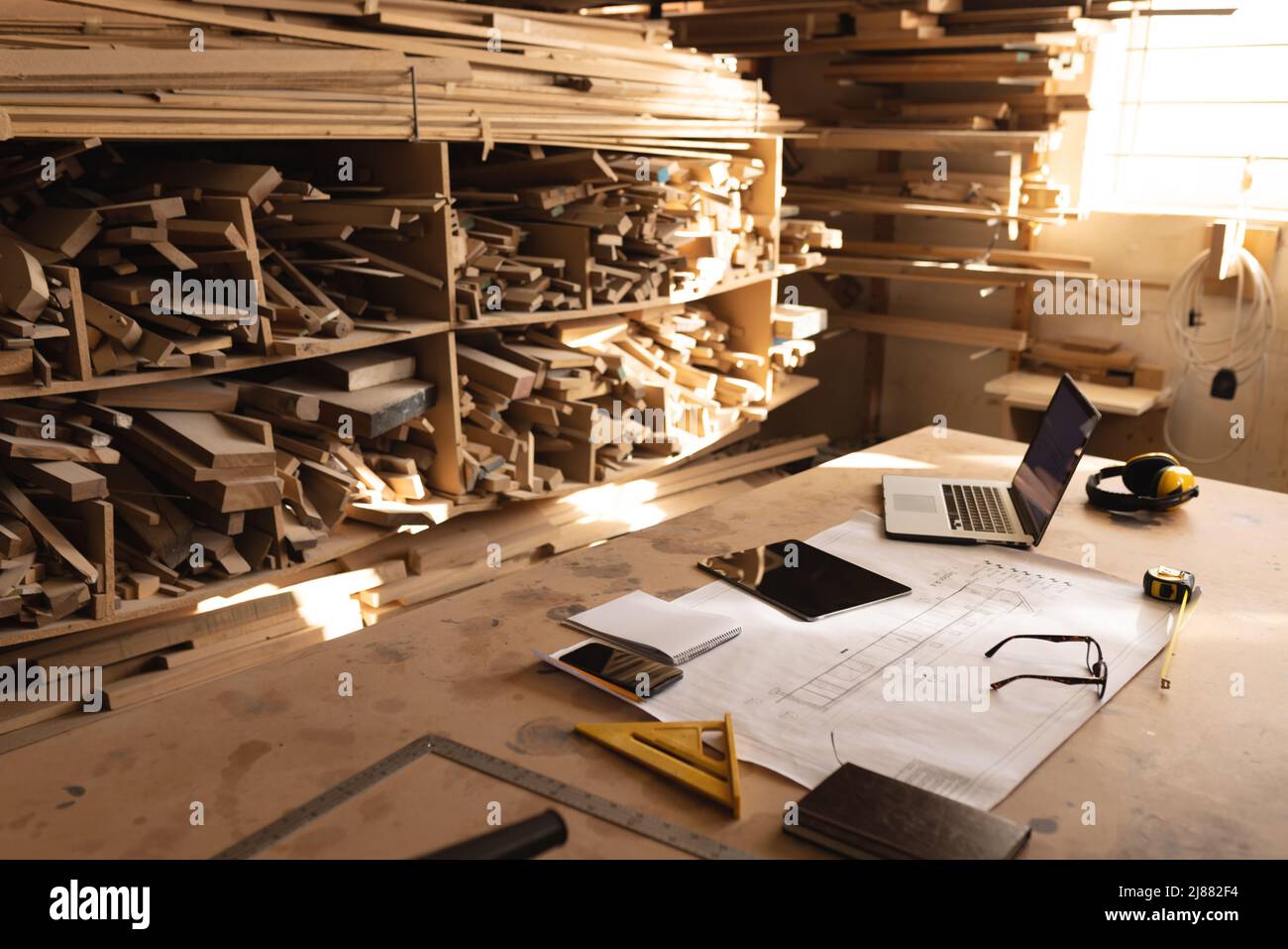 Interno dell'officina con Blueprint e tecnologie wireless di fronte al legno Foto Stock