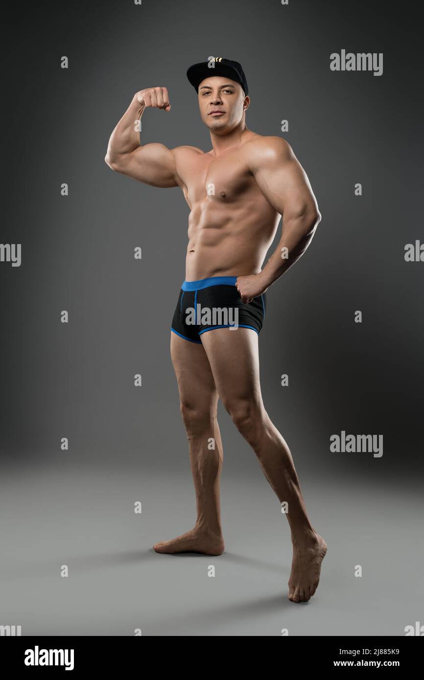 Uomo muscolare con torso nudo che mostra bicep Foto Stock