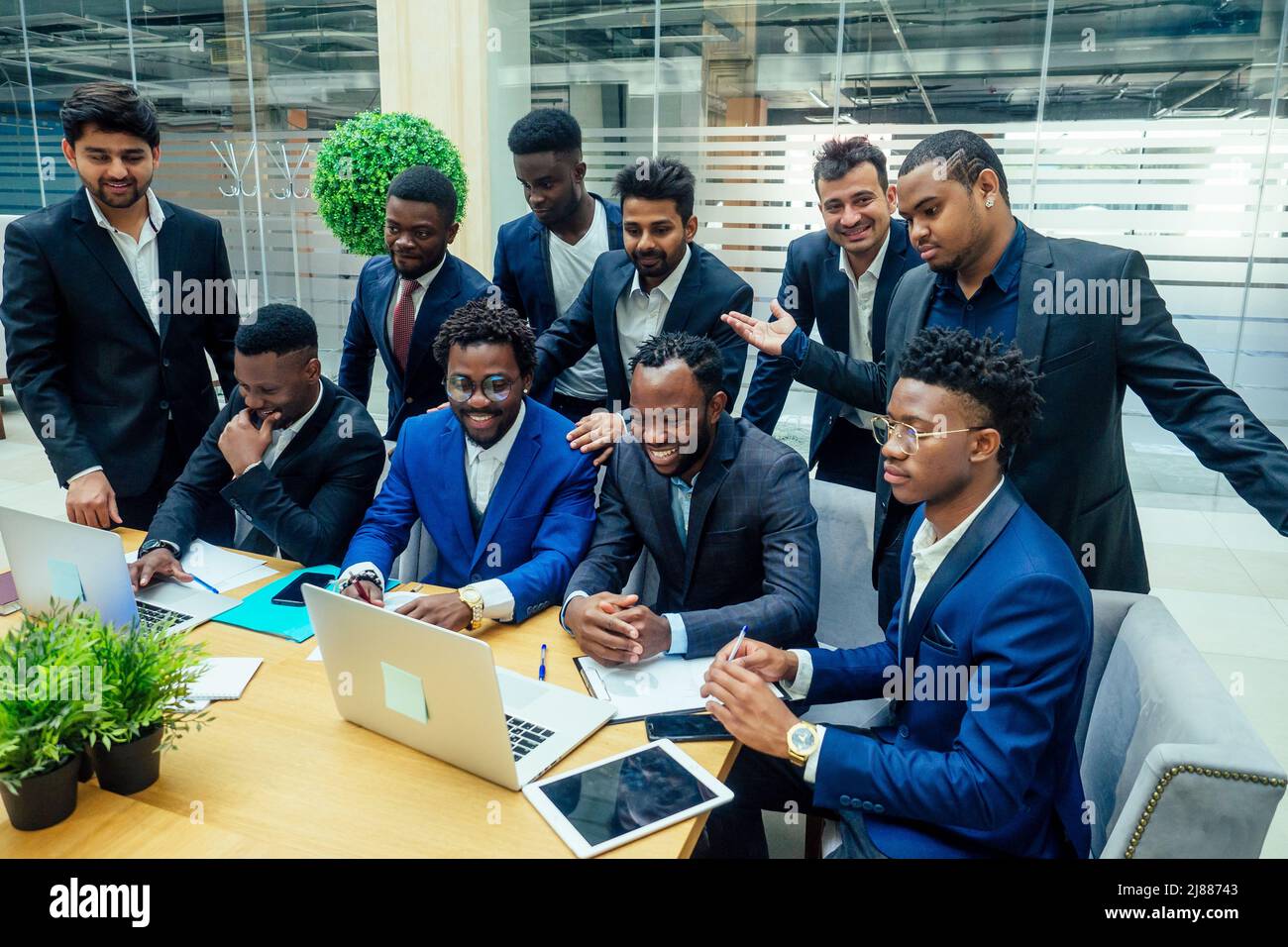 Gruppo di uomini d'affari internazionali che guardano il grafico su lavagna a fogli mobili in un moderno ufficio ecologico Foto Stock