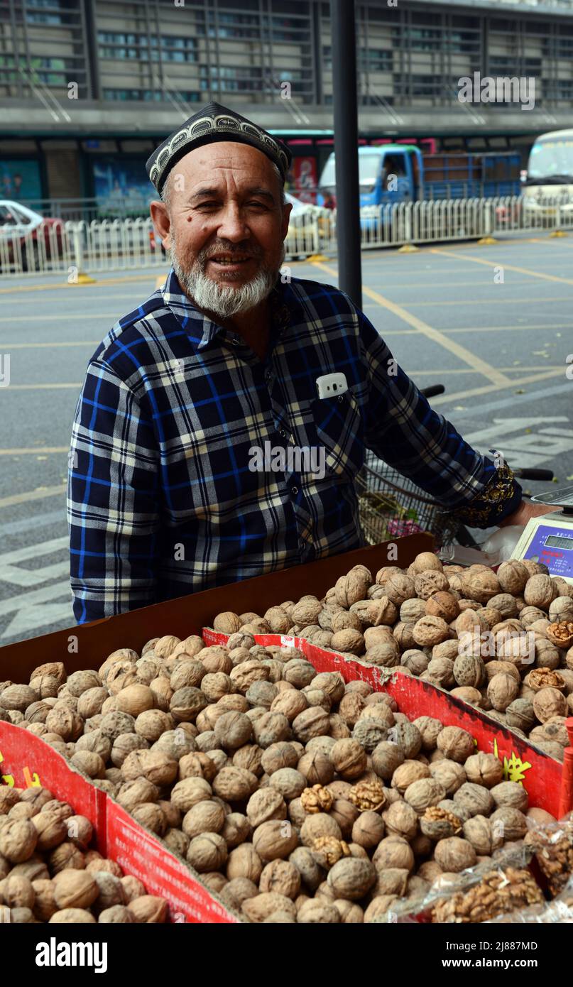 Un uomo di Uygur che vende noci a Shenzhen, Cina. Foto Stock