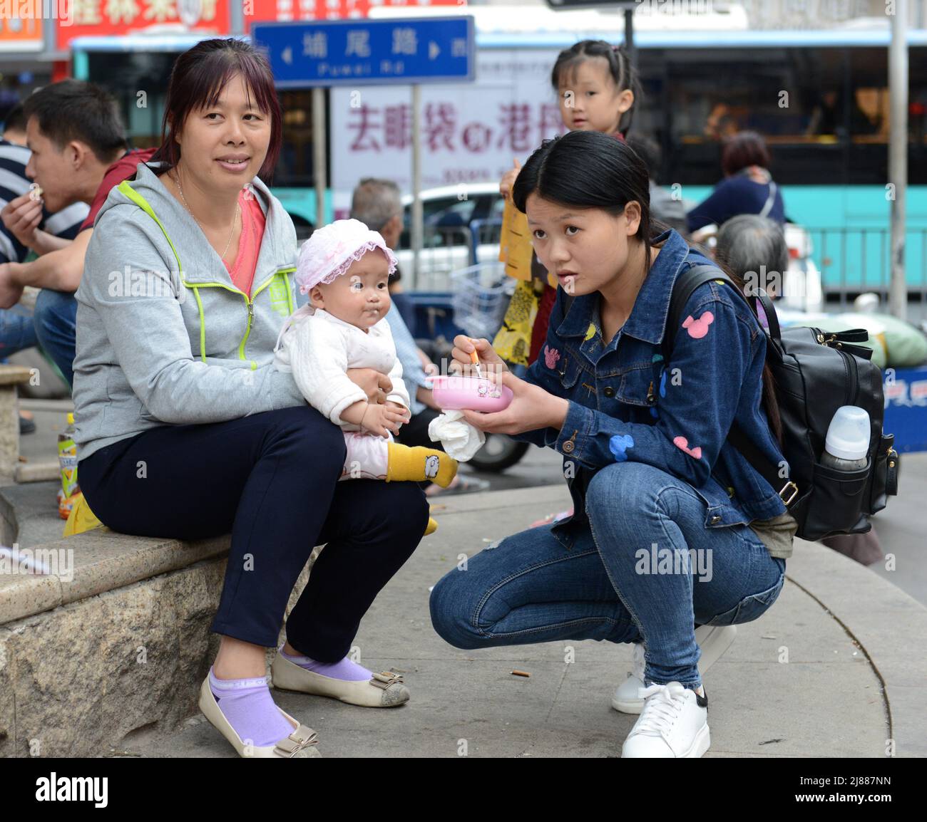 Una donna cinese che alimenta il suo bambino. Shenzhen, Cina. Foto Stock