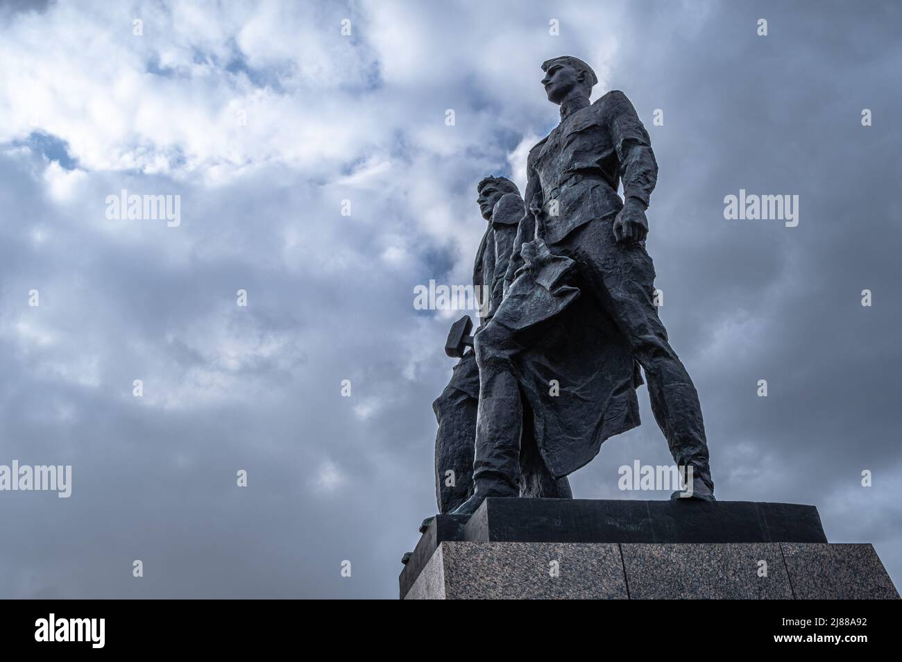 Monumento ai soldati sovietici contro cieli nuvolosi. Frammento del complesso commemorativo intitolato 'agli eroici difensori di Leningrado'. San Pietroburgo. Foto Stock