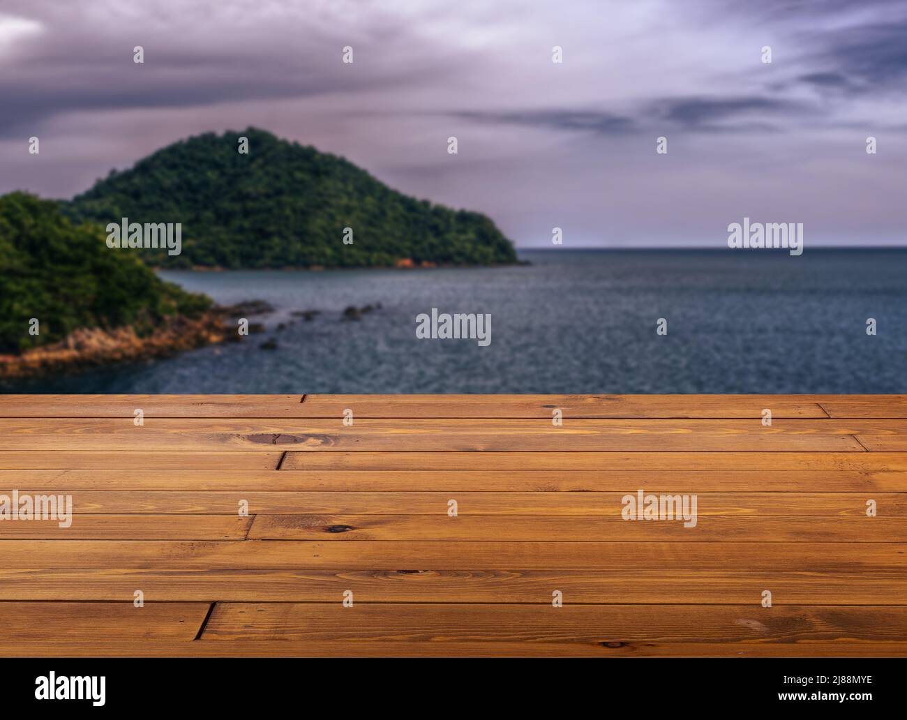 Bella tavola marrone in legno o pavimento della scrivania, piccola superficie lucida, vista prospettica, sfondo di paesaggio sfocato di cielo e mare drammatico. Foto Stock