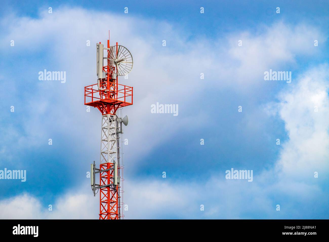 Palo radio (torre) con antenne per telecomunicazioni e trasmissioni e cielo nuvoloso. Primo piano Foto Stock