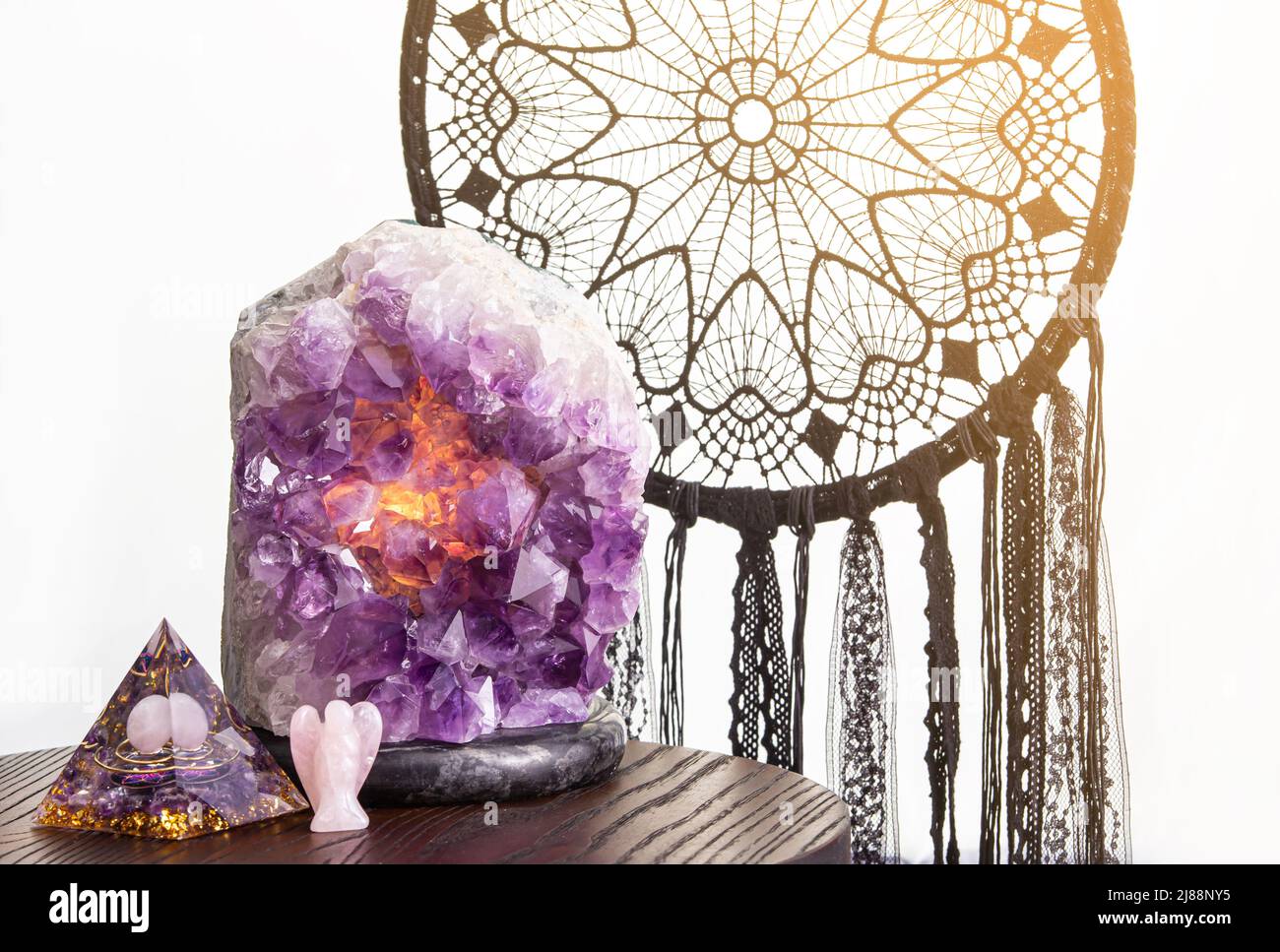 Concetto di decorazione domestica spirituale. Vari elementi: Piramide orgonite o Orgone, catcher di sogno di colore nero, figurina a forma di angelo di quarzo rosa. Foto Stock