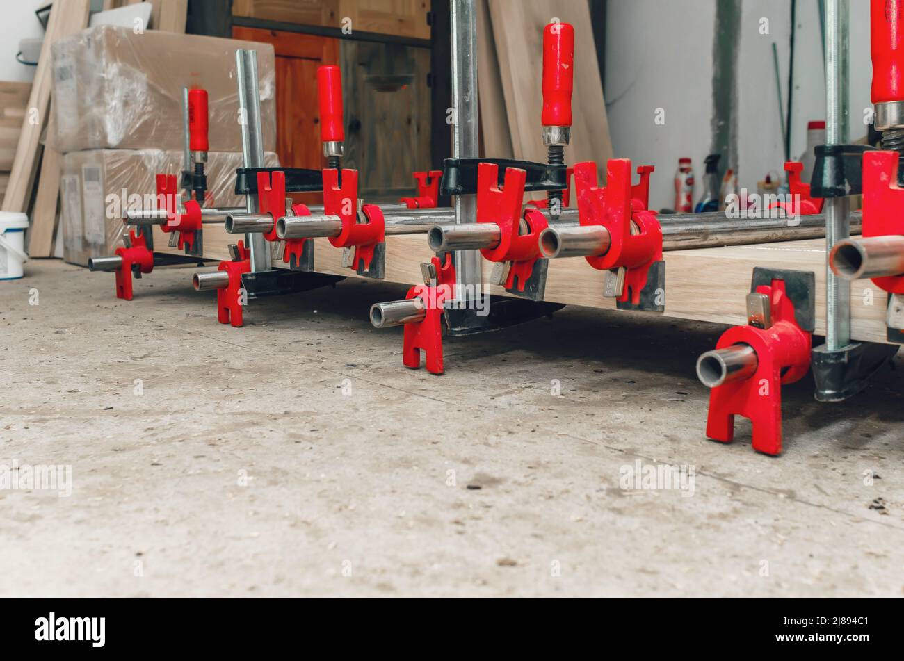 Morsetti per giuntatrice sulla lunghezza della barra. Asse di legno. Vista laterale Foto Stock