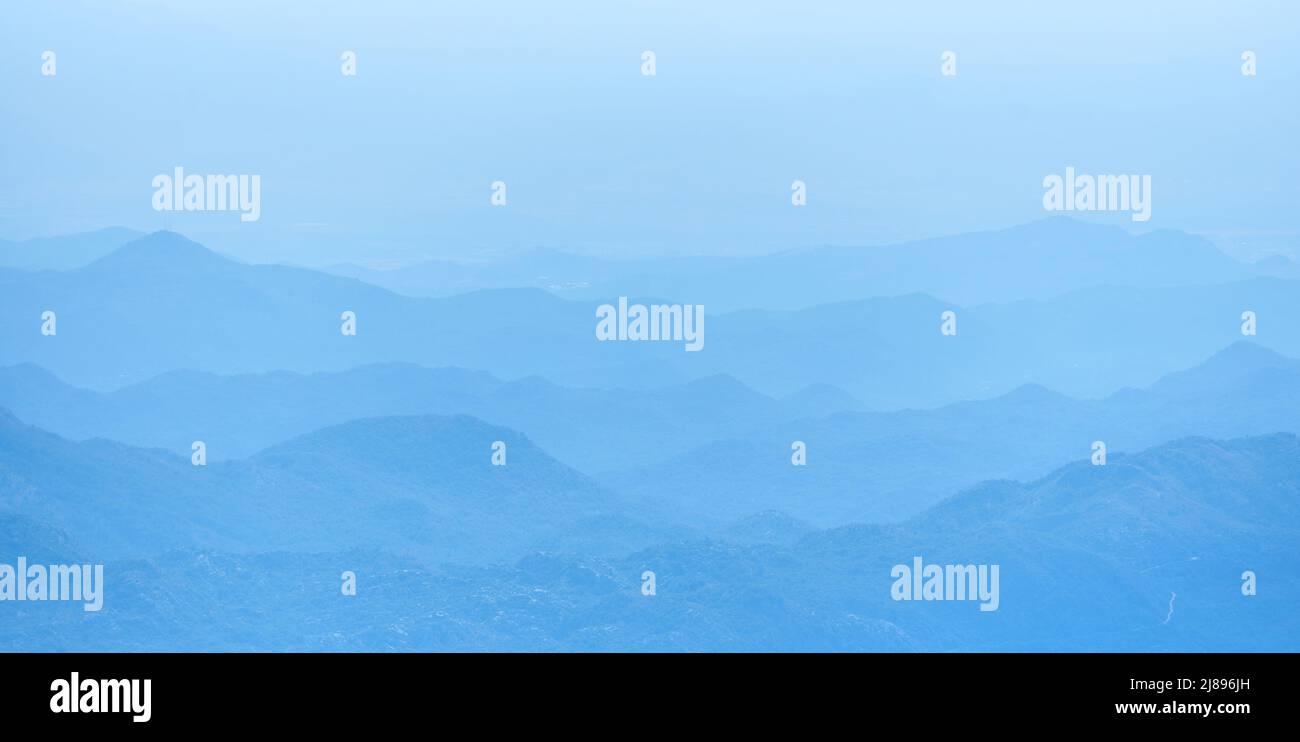 Paesaggio di una silhouette a strati della catena montuosa blu Foto Stock