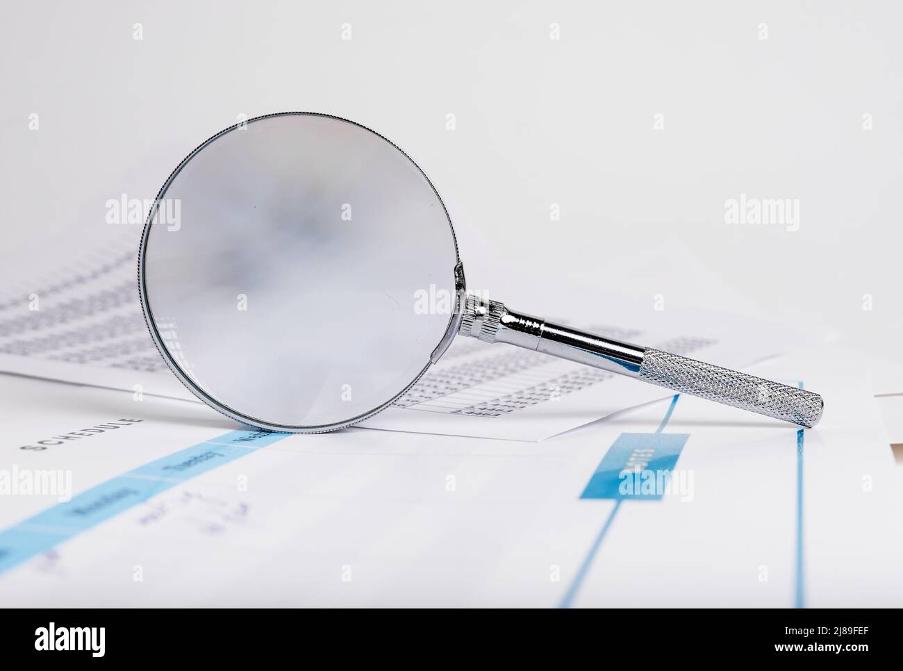 Ricerca aziendale astratta con documenti finanziari e lente d'ingrandimento. Foto di alta qualità Foto Stock