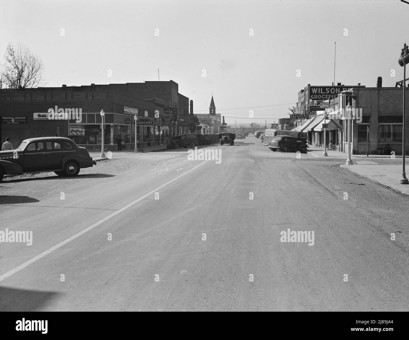 Strada principale di Nyssa, Oregon. Sabato pomeriggio. [Segni: 'International Harvester - McCormick-Deering Farm Machines; Dutch Boy Paints; hardware; Grocery; Rexall Drugs; Non residenti Registrati qui; Cafe; Dime Store; Golden Rule; Atkeson's Clothing - Donna Apparel; Rose Bud Club; Meats; Wilson Bros Groceries; Headquarters vale-Owyhee Land Settlement Association']. Foto Stock