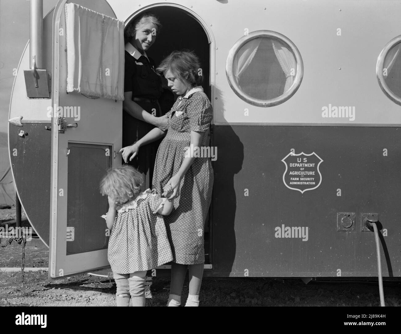 La giovane madre porta il suo bambino nella clinica del rimorchio il giorno in cui il medico sarà nel campo per esaminare alcuni dei bambini. Contea di Klamath, Oregon. Campo FSA (Farm Security Administration). Foto Stock