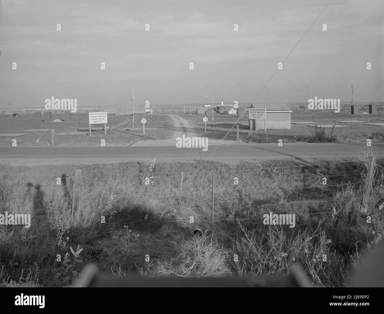 Ingresso al campo di lavoro familiare Nyssa Farm, unità mobile FSA (Farm Security Administration) numero 1, appena stabilito prima dell'apertura della stagione delle barbabietole. Vicino a Nyssa, Oregon. [Segni: "United States Dept. Of Agriculture - Farm Security Administration - Migratory Labor Camp - Mobile Unit No.1"]. Foto Stock