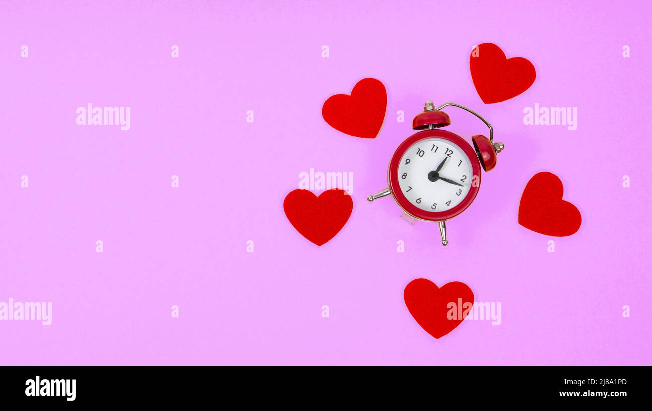 Cuori sentiti e sveglia con copyspace per il 8 marzo l'amore del giorno delle donne su sfondo viola viola Foto Stock