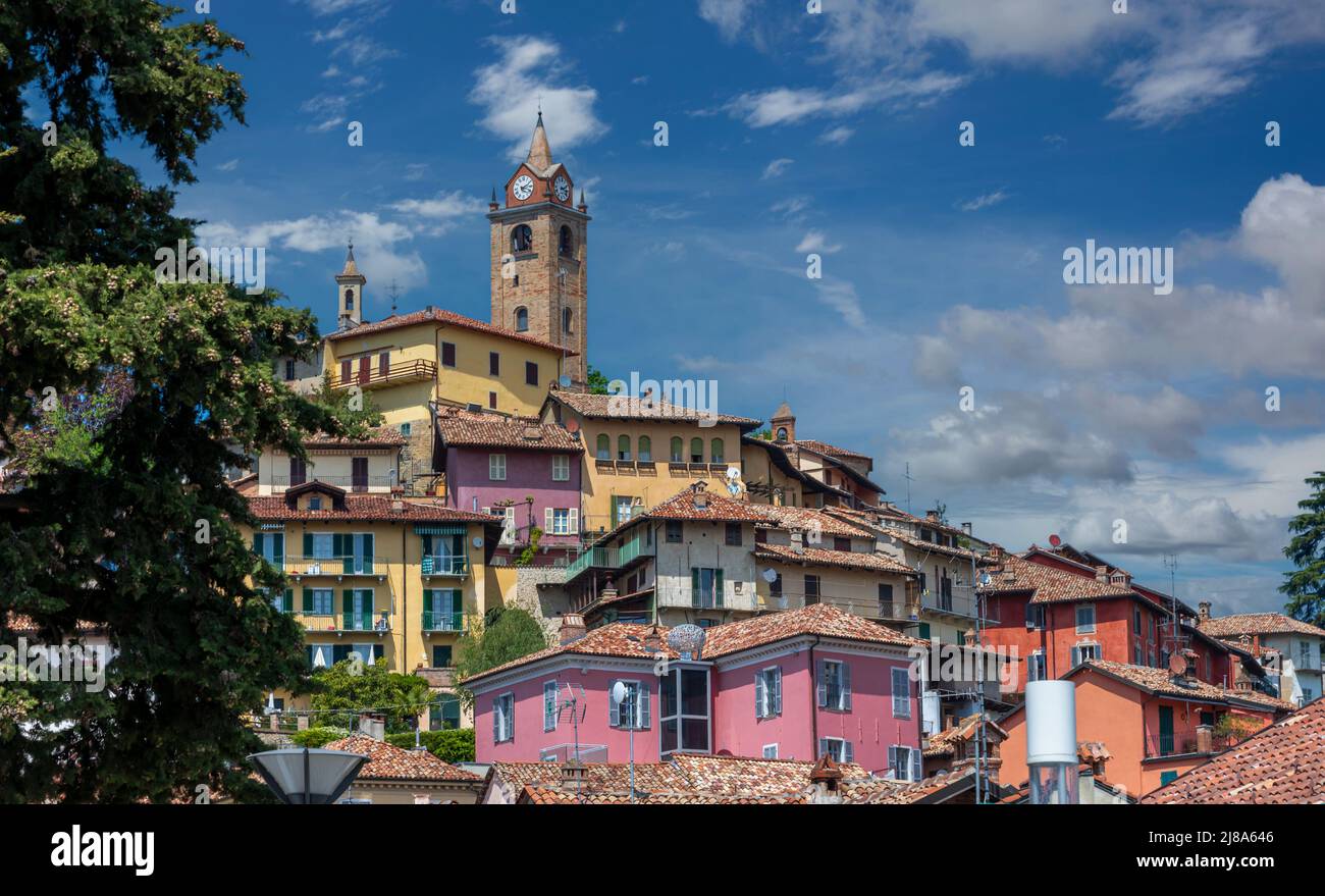 Monforte d'Alba, langhe, Italia: Vista del borgo medievale sulla collina con l'antico campanile e caratteristici edifici colorati su cielo blu e. Foto Stock