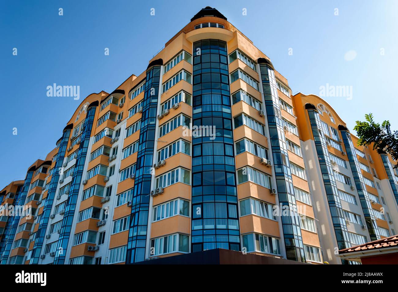 Vista esterna di un moderno edificio residenziale a più piani. Facciata, finestre e balconi. Giorno d'estate. Foto Stock