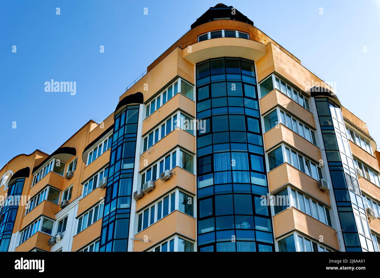 Vista esterna di un moderno edificio residenziale a più piani. Facciata, finestre e balconi. Giorno d'estate. Foto Stock