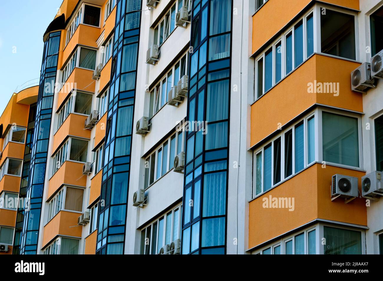 Vista esterna di un moderno edificio residenziale a più piani. Facciata, finestre e balconi. Giorno d'estate. Foto Stock