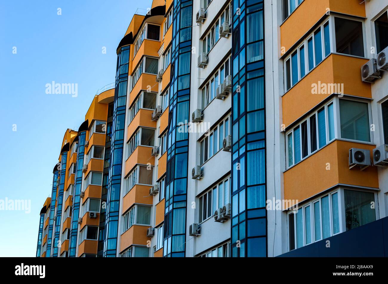 Vista esterna di un moderno edificio residenziale a più piani. Facciata, finestre e balconi. Giorno d'estate. Foto Stock