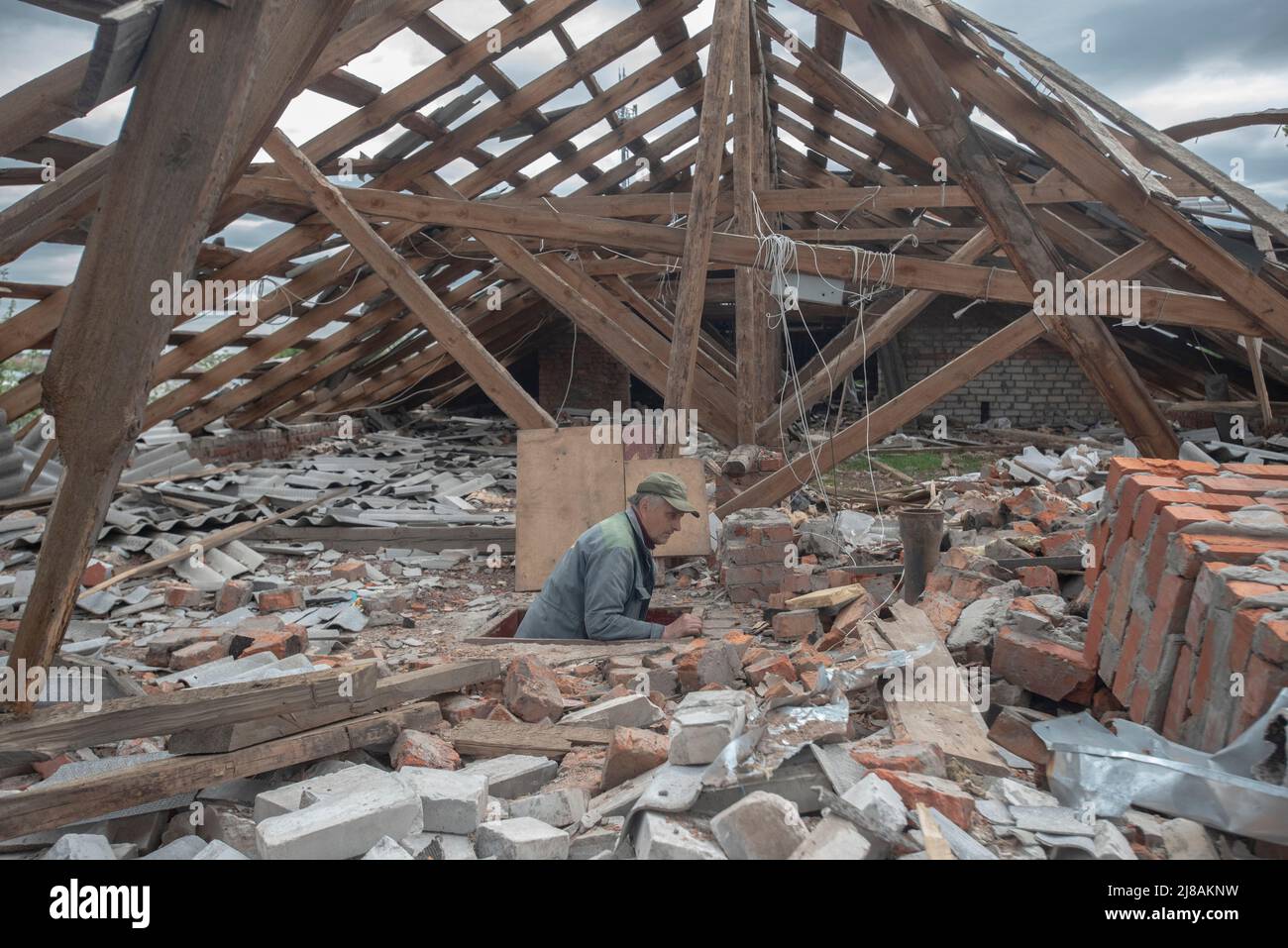 Ucraina. 11th maggio 2022. Un uomo sul tetto della sua casa a Chirkunye, Kharkiv, Ucraina. Mercoledì 11th maggio di 2022. L'invasione russa dell'Ucraina per ordine di Vladimir Putin nel febbraio 2022 ha prodotto grandi sfollamenti di persone e una grande reazione da parte dell'opinione pubblica e delle forze politiche in tutto il mondo le forze militari russe sono entrate in territorio ucraino il 24 febbraio 2022. (Foto di Andoni Lubaki/Sipa USA) Credit: Sipa USA/Alamy Live News Foto Stock