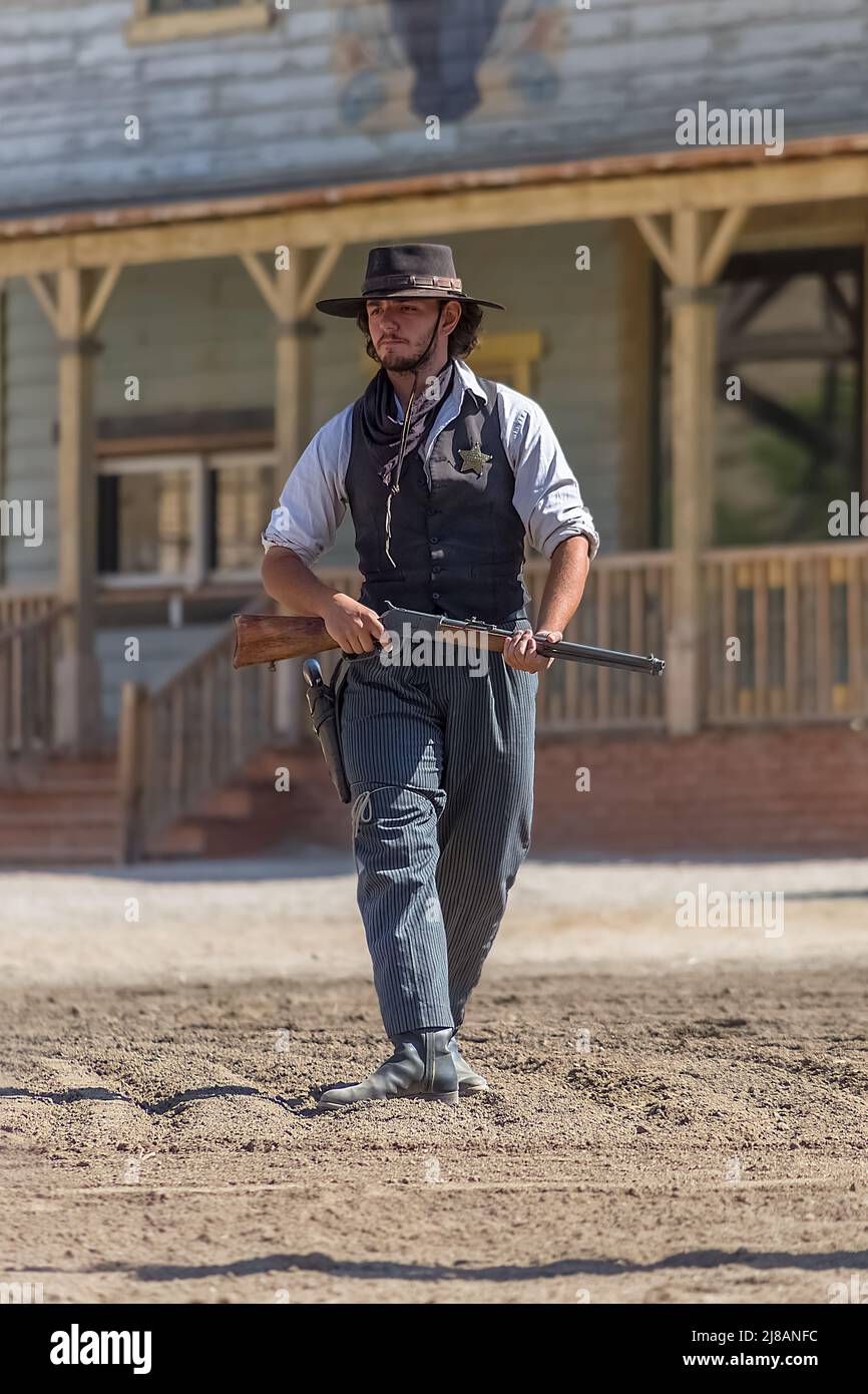 Alméria Spain - 09 15 2021: Scene di spettacolo dal vivo, cowboy sheriff a piedi con fucile a mano, su Oasys - Mini Hollywood, spagnolo Western tema pa Foto Stock