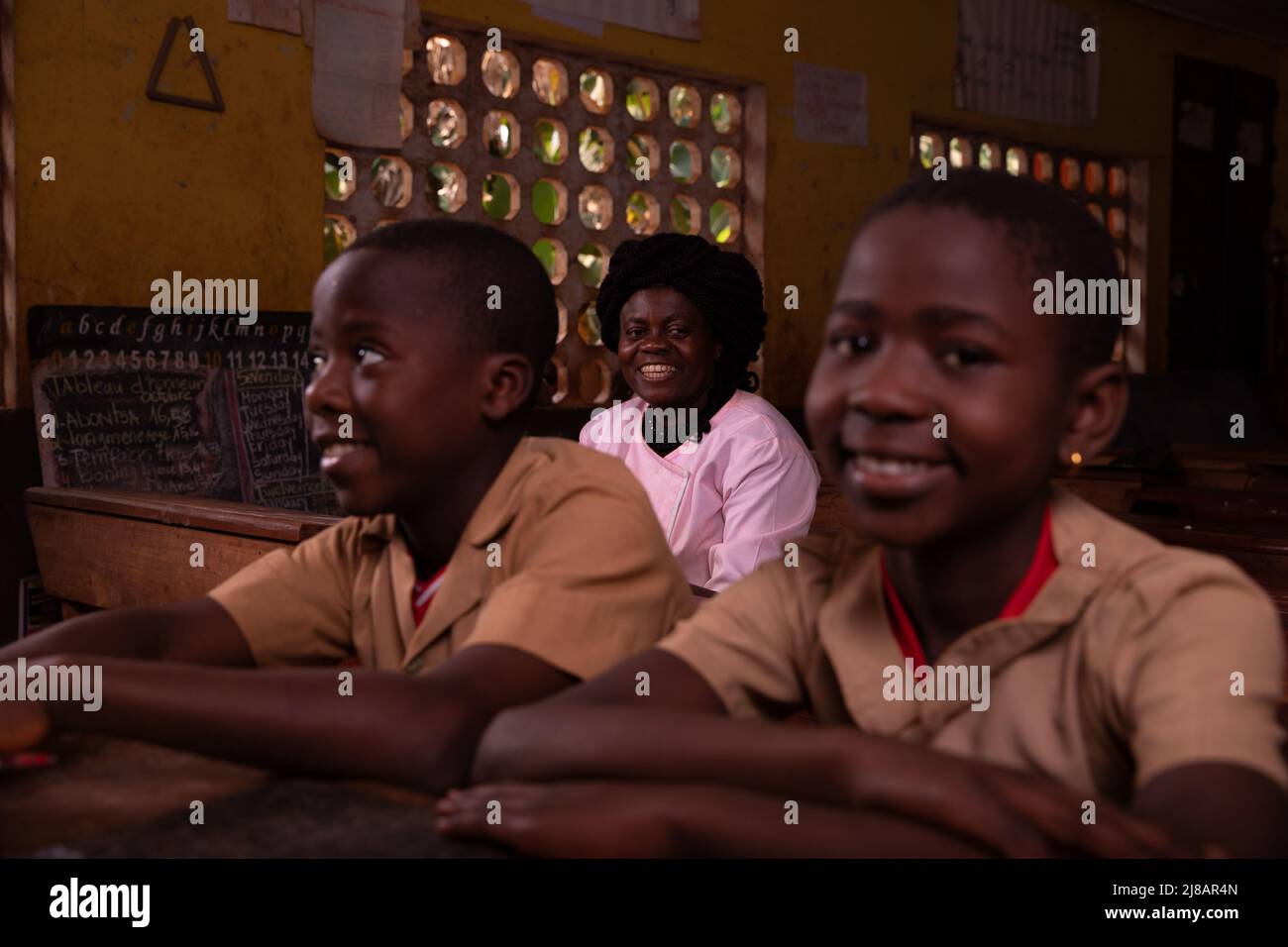 Insegnante africano seduto in aula con i suoi allievi. Foto Stock