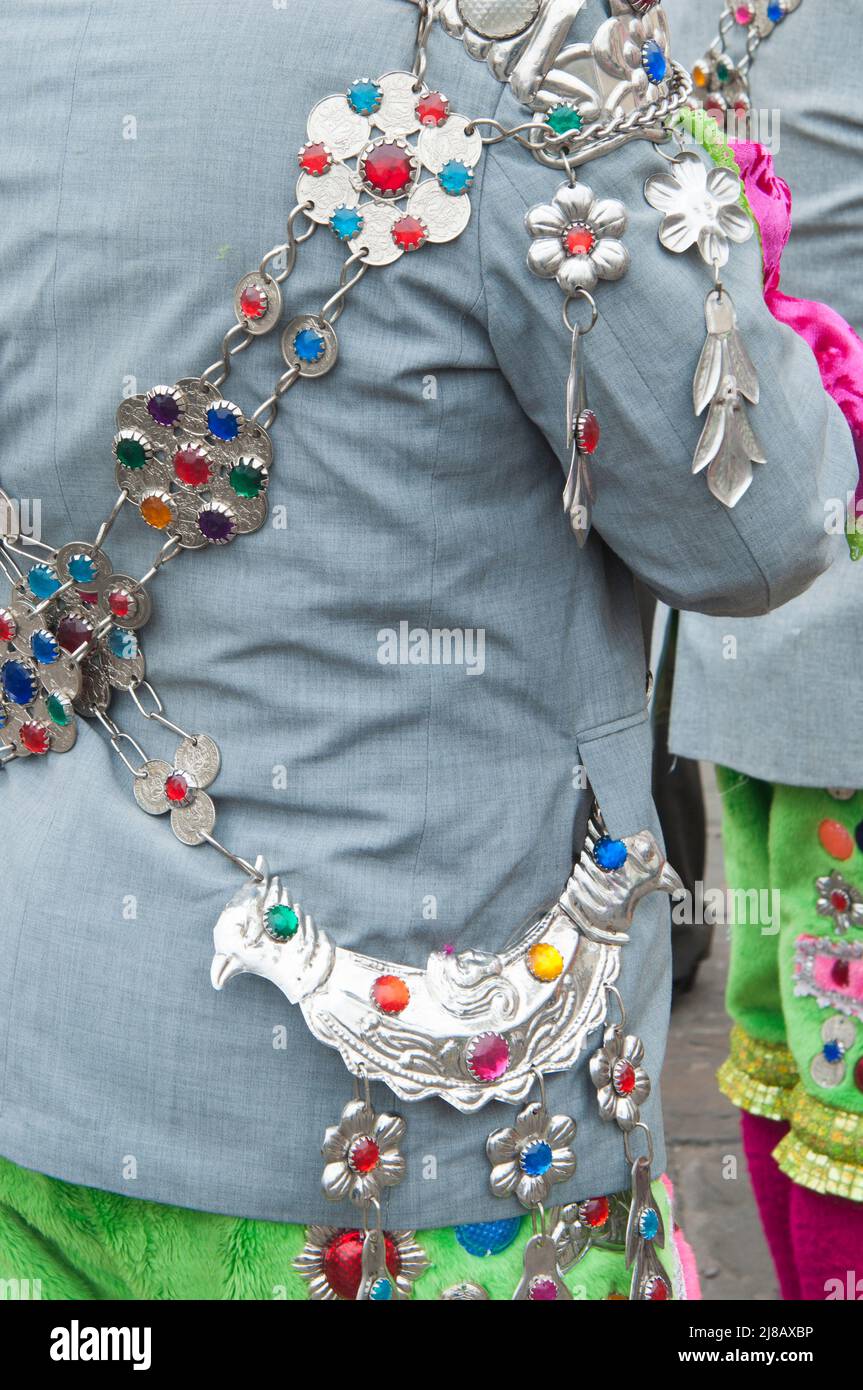 Lima, Perù; 09092012: Primo piano di splendidi ornamenti d'argento su abiti peruviani tradizionali, l'uomo visto dalla sua schiena indossare giacca grigia e coriandolo verde Foto Stock