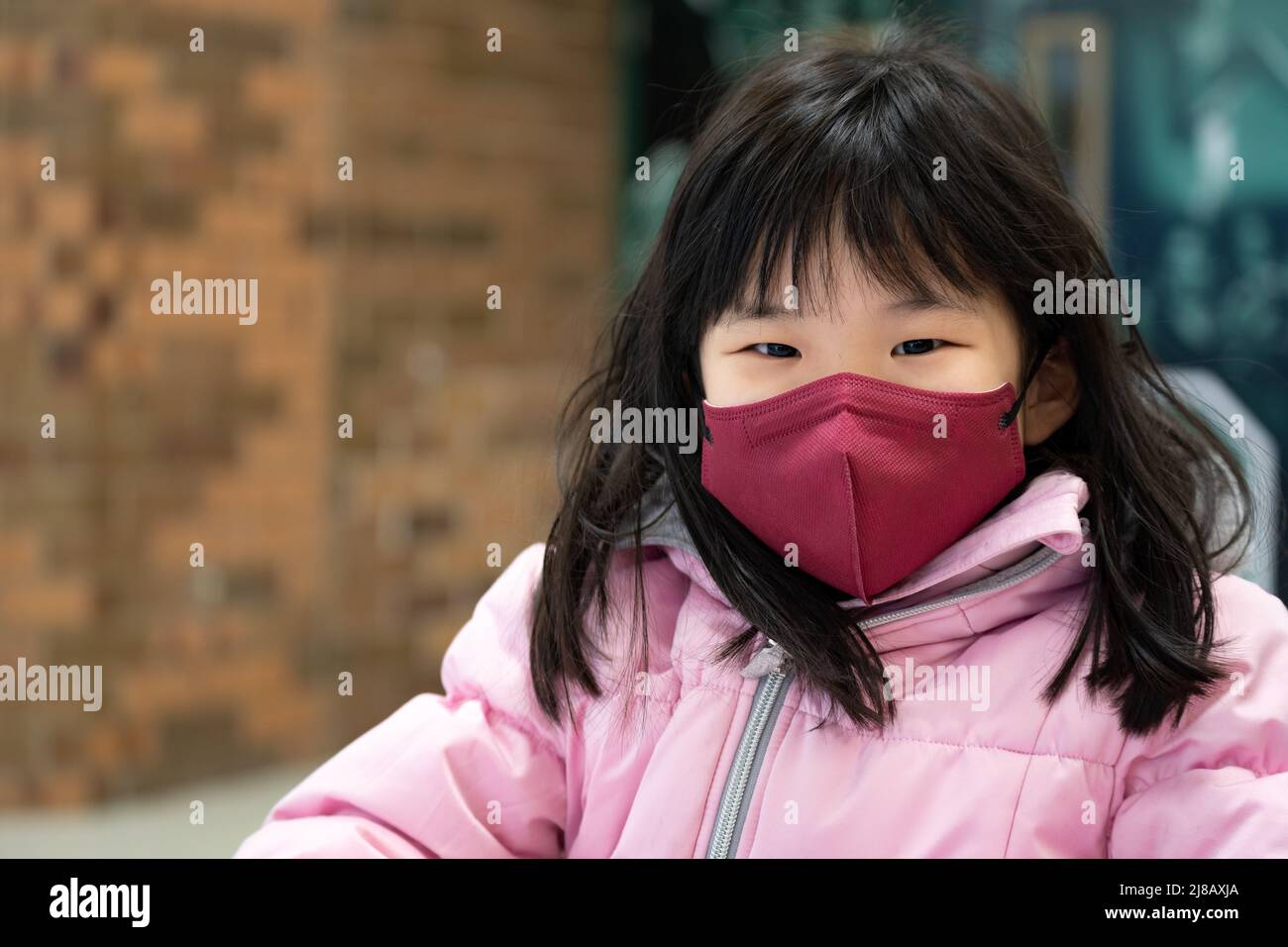 Piccola ragazza asiatica capretto che indossa maschera facciale Foto Stock