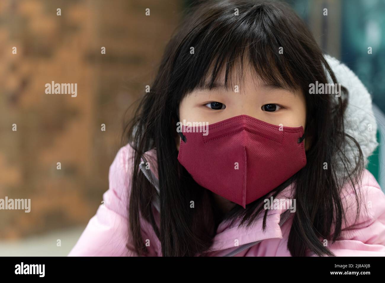 Piccola ragazza asiatica capretto che indossa maschera facciale Foto Stock