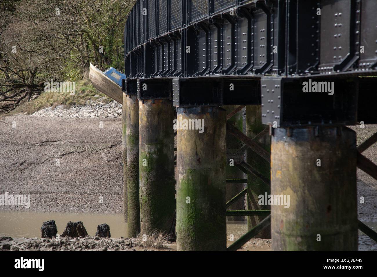 Dopo una grande marea primaverile oggi una piccola barca si è rotta libera dal suo ormeggio e sembra essere appesa sotto un vecchio ponte ferroviario a Fremington Quay, nel Devon del Nord. L'alta marea era alle 7,59 di mattina e come la marea ha recitato la piccola barca blu e bianca è stata lasciata a 30 piedi dangling sopra l'ora bassa marea, con il suo proprietario da nessuna parte per essere visto. I locali hanno detto che non sanno chi possiede la barca ma che viene alta marea, intorno alle 8,20pm questa sera, dovrebbe uscire e galleggiare di nuovo. Con: Vista, Barca intrappolata dove: Fremington, Devon, Regno Unito quando: 30 Mar 2021 credito: Foto Stock