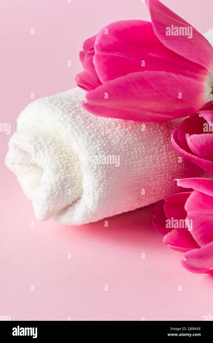 Prodotti per la cura della pelle Spa su sfondo rosa. Cosmetici naturali e tulipani rossi. Posiziona per il testo. Foto Stock