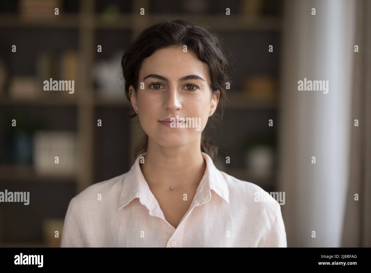 Headshot ritratto seria giovane donna che fissando la macchina fotografica posa in interno Foto Stock