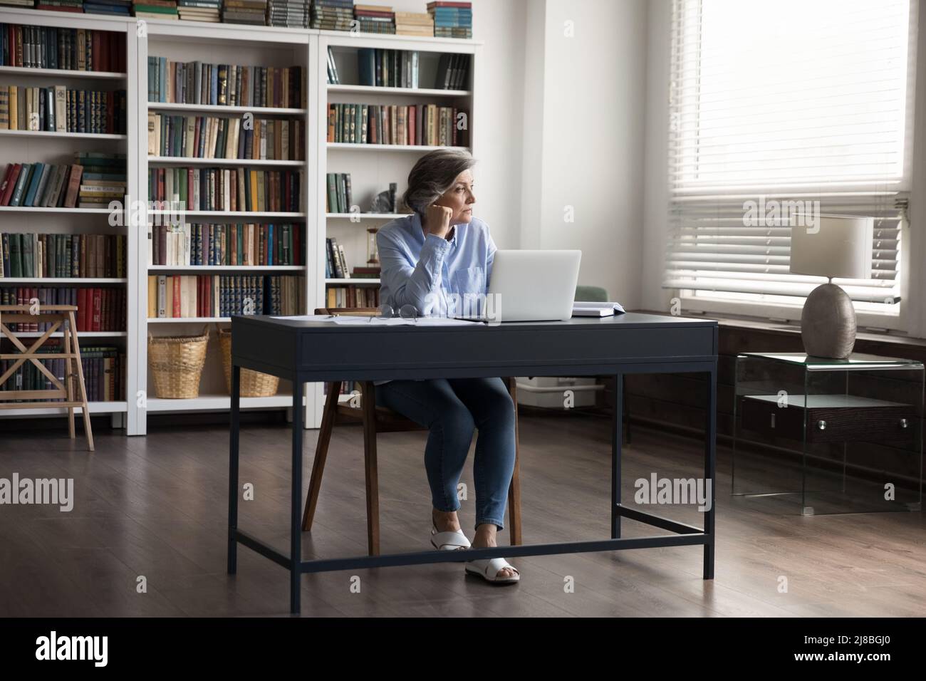 Preoccupata premurosa donna professionale di mezza età che usa il laptop Foto Stock