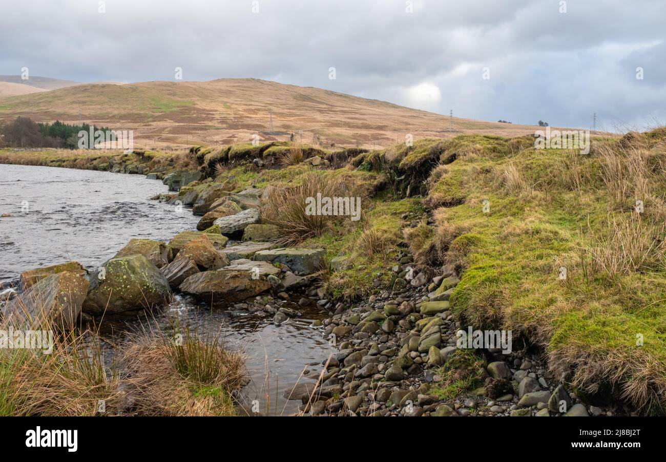 Protezione contro l'erosione fluviale fallita con rocce dragate rip-rap lavate da una riva del fiume in Scozia Foto Stock