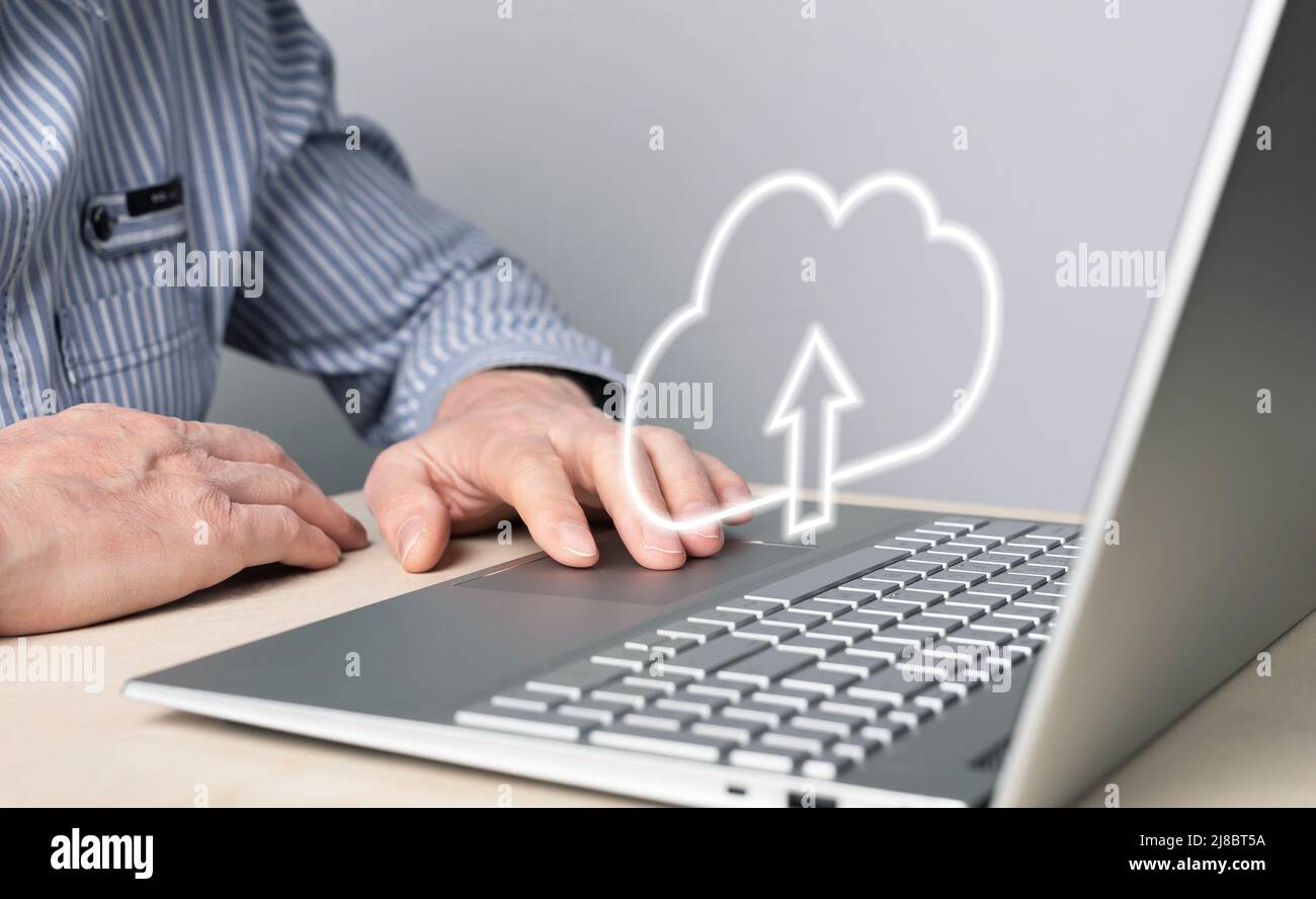 Cloud computing. Uomo che usa il laptop per caricare, archiviare o condividere file online. Mano maschio sul touchpad del computer primo piano. Foto di alta qualità Foto Stock